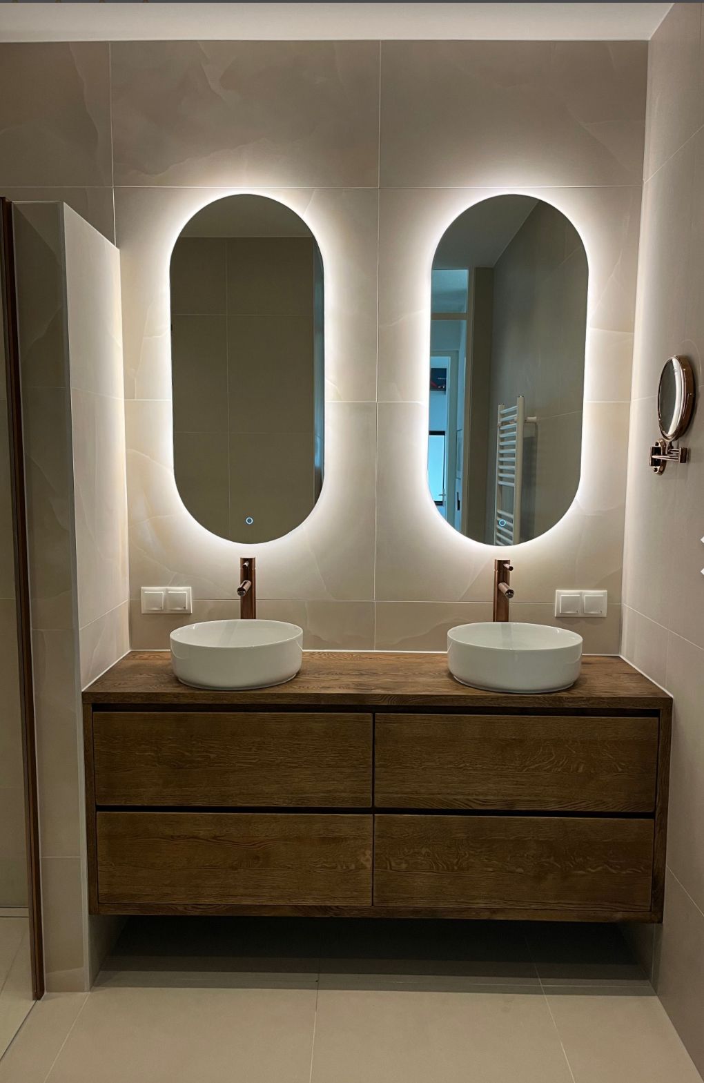 Luxe badkamer met verlichte spiegels en houten meubel